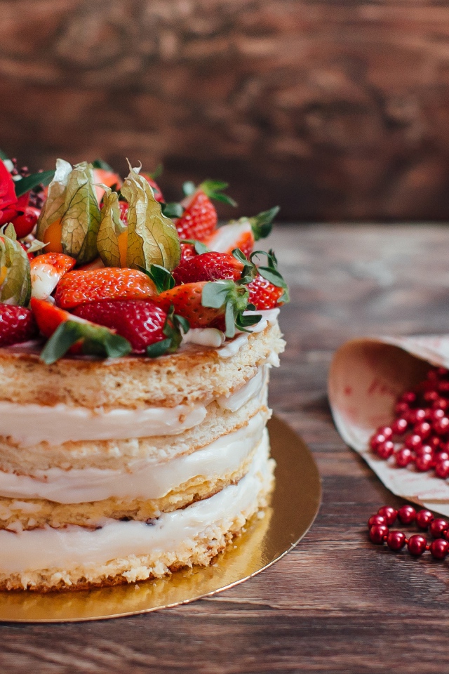 Торт с коржами и ягодным кремом украшен клубникой 