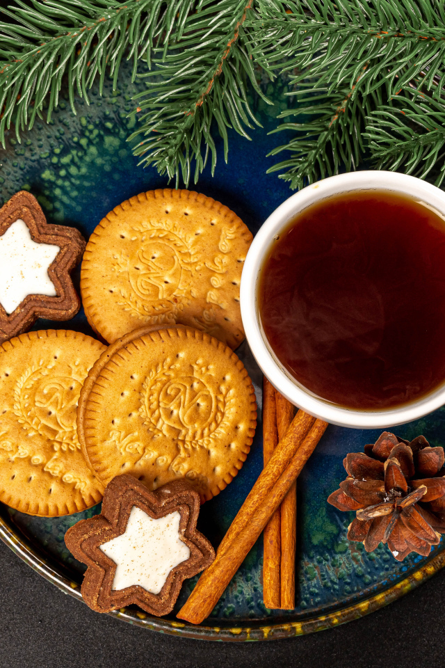 Печенье, чай и корица на столе с еловой веткой