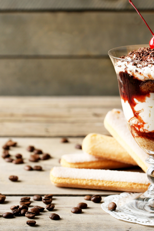 Десерт с печеньем савоярди на столе с кофейными зернами