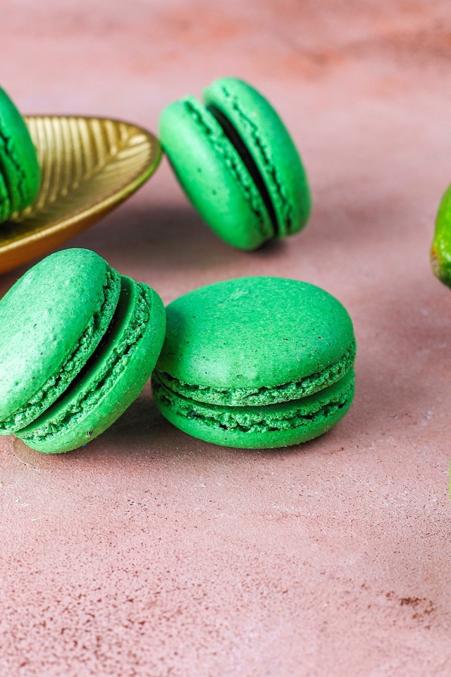 Зеленый десерт макарун на столе с лаймом