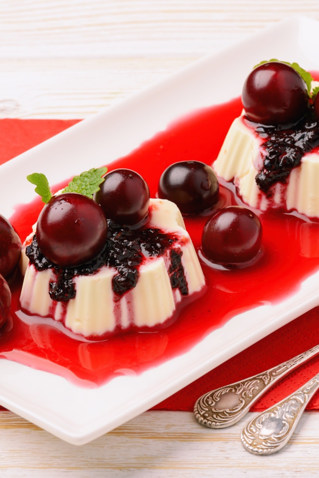 Молочный десерт на тарелке с вишней