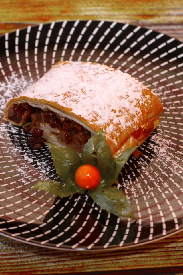 Кусок яблочного штруделя на тарелке 