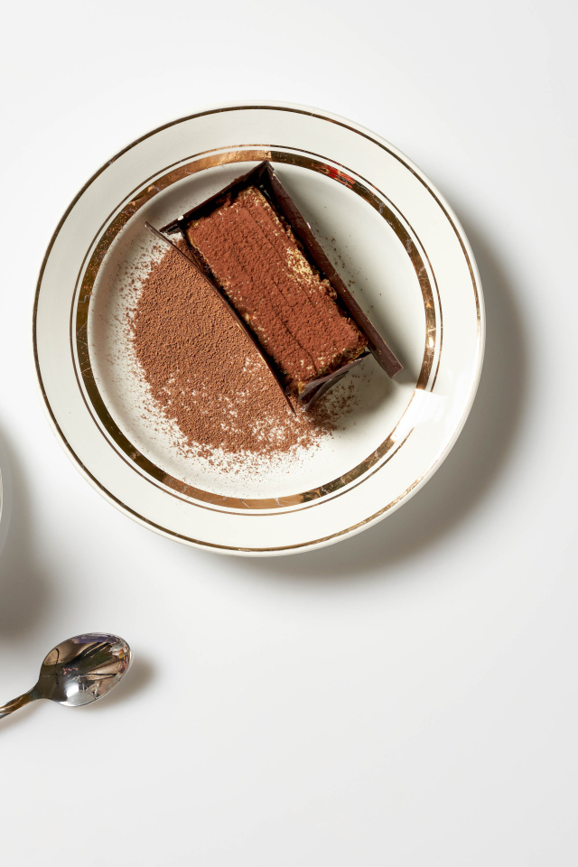 Кусок торта на столе с чашкой кофе 