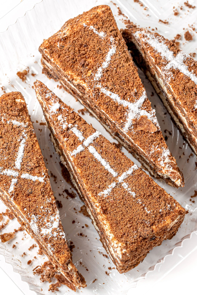 Куски аппетитного медового торта на белом фоне