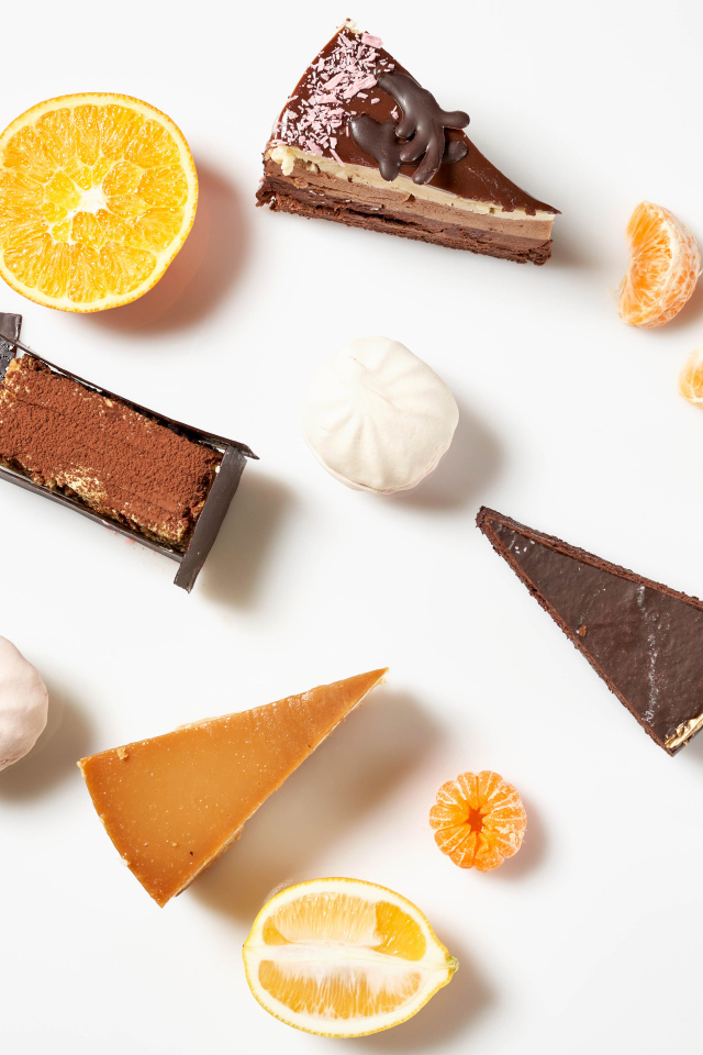 Куски торта на белом фоне с мандарином и лимоном