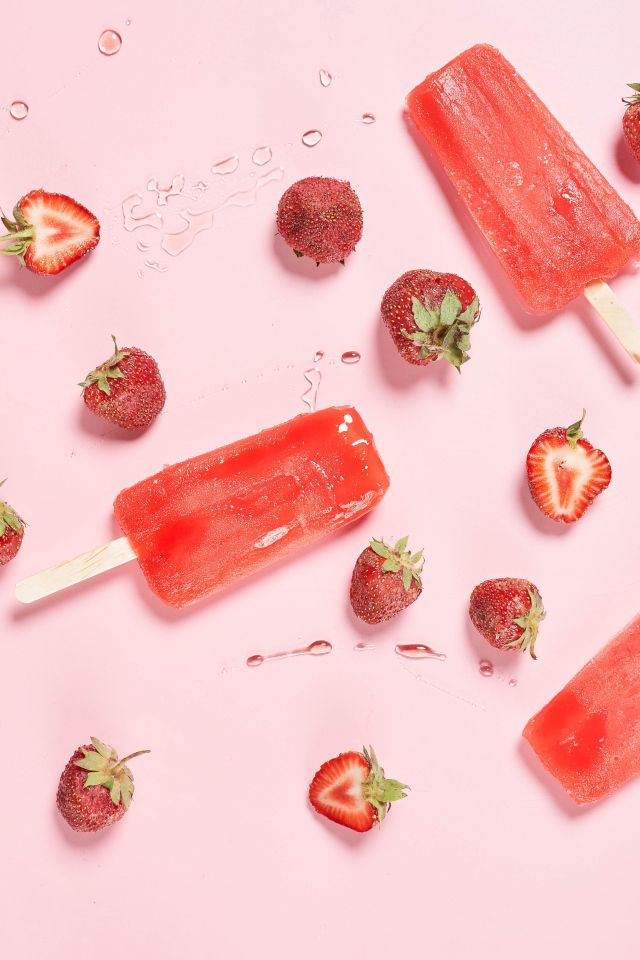 Фруктовое мороженое на розовом фоне с ягодами клубники 