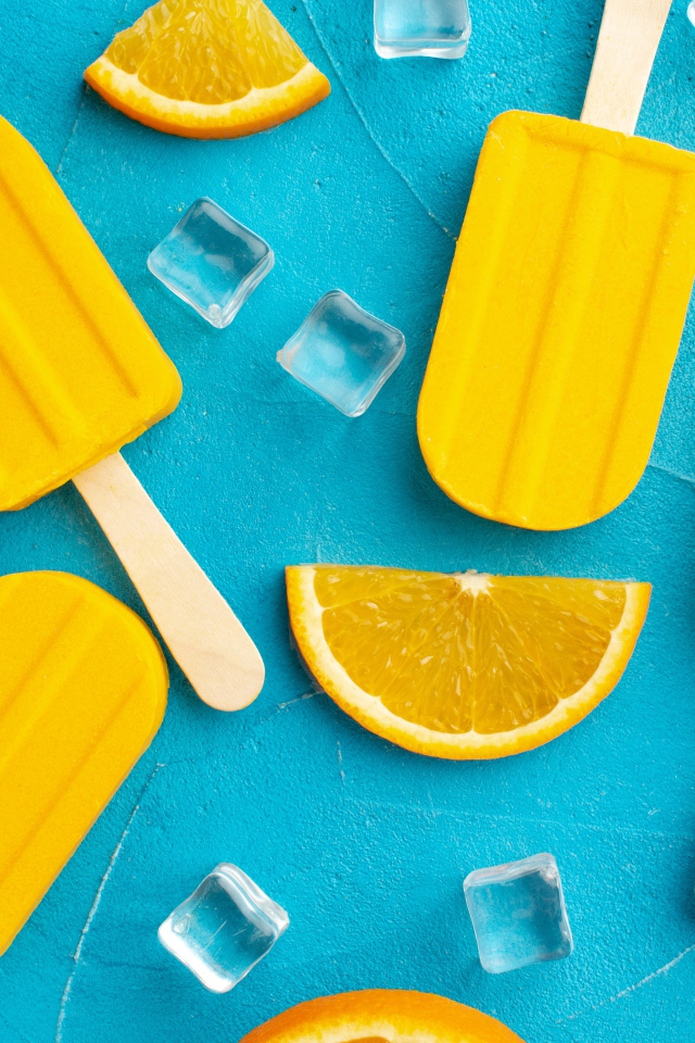 Фруктовое мороженое с кусочками льда и апельсина на голубом столе 