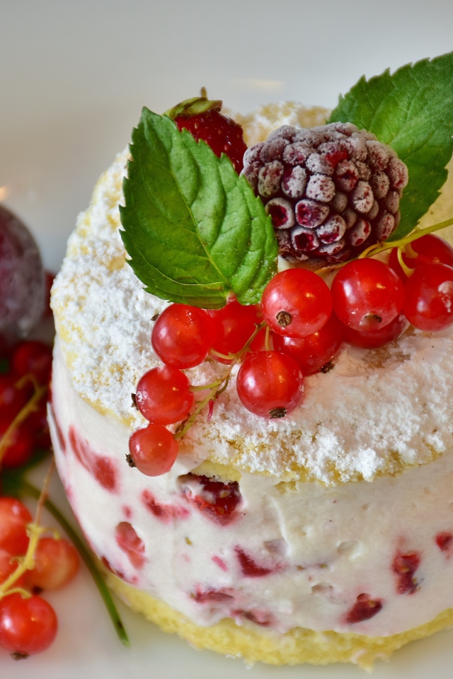 Пирожное со взбитыми сливками украшено ягодами