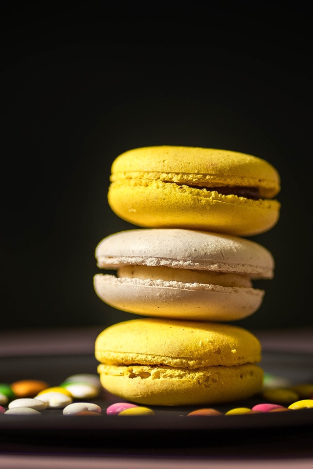 Желтый десерт макарун на тарелке