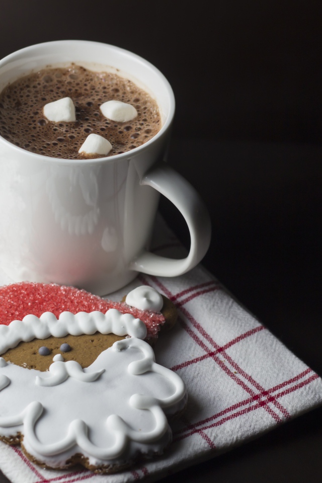 Чашка кофе с праздничным печеньем на черном фоне