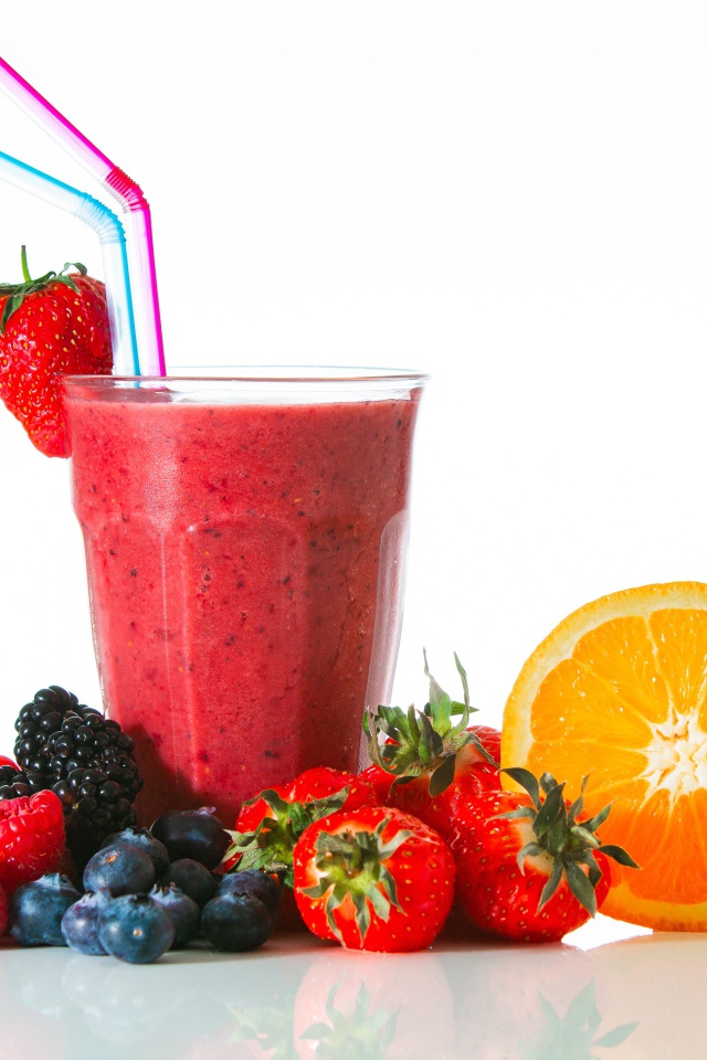 Стакан свежего смузи на столе с ягодами