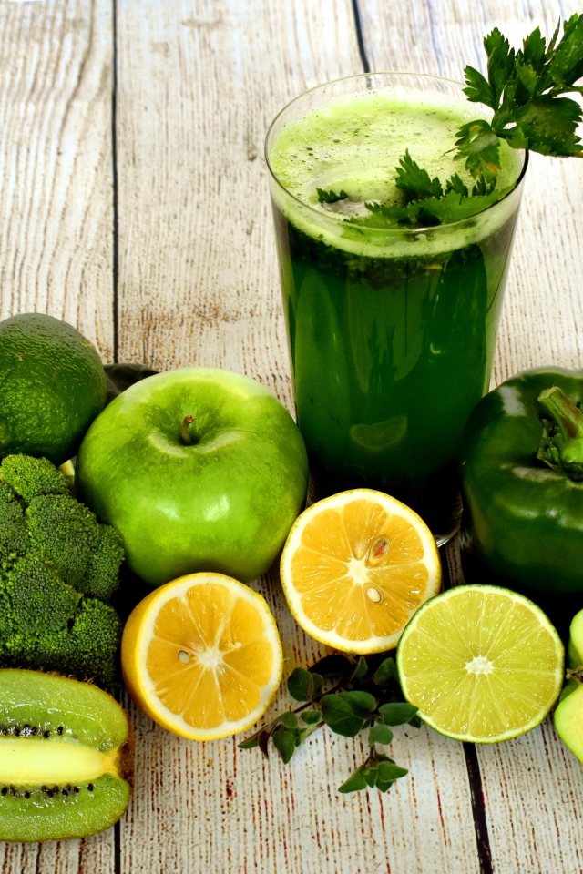 Зеленый свежий смузи на столе с овощами и фруктами 