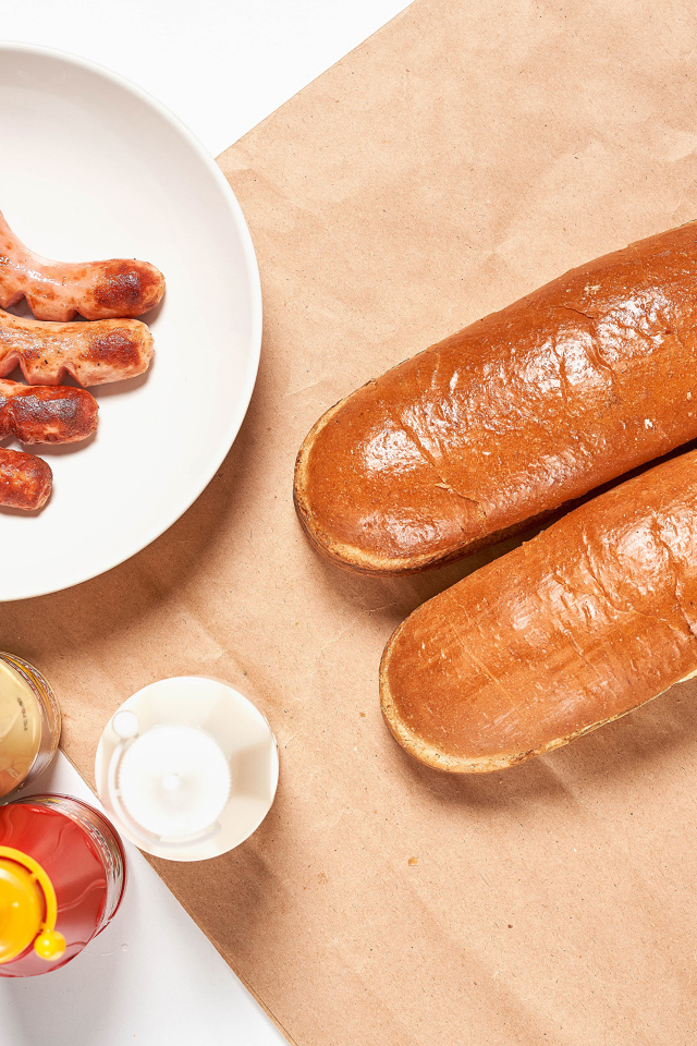 Hot dog rolls with sausages on the table with sauce