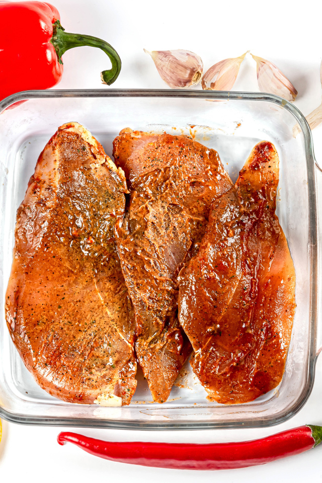 Маринованное мясо на столе со специями и соусом