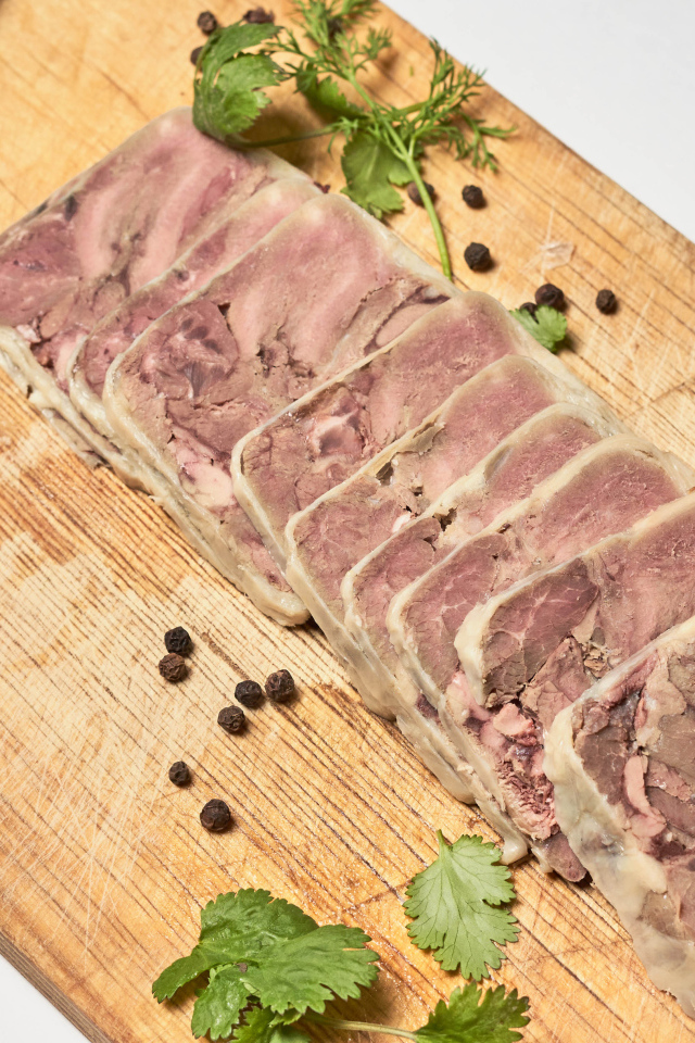 Мясной продукт на деревянной доске с ножом 