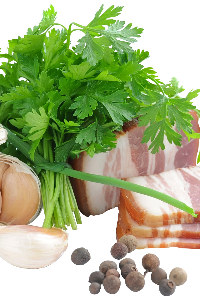 Кусок сала на белом фоне с зеленью петрушки и специями