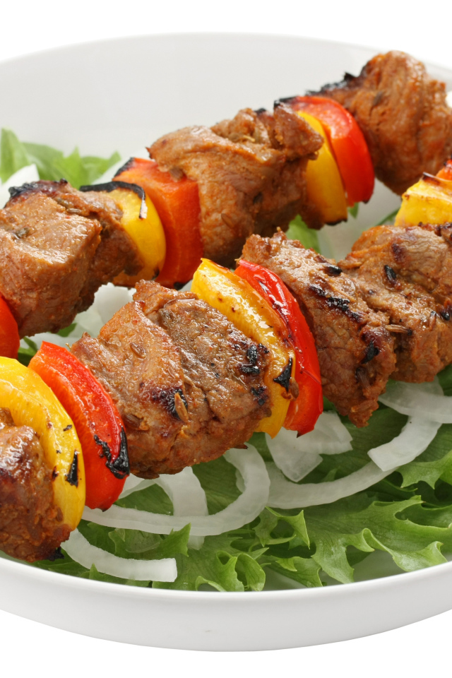 Шашлык с болгарским перцем на тарелке с листьями салата
