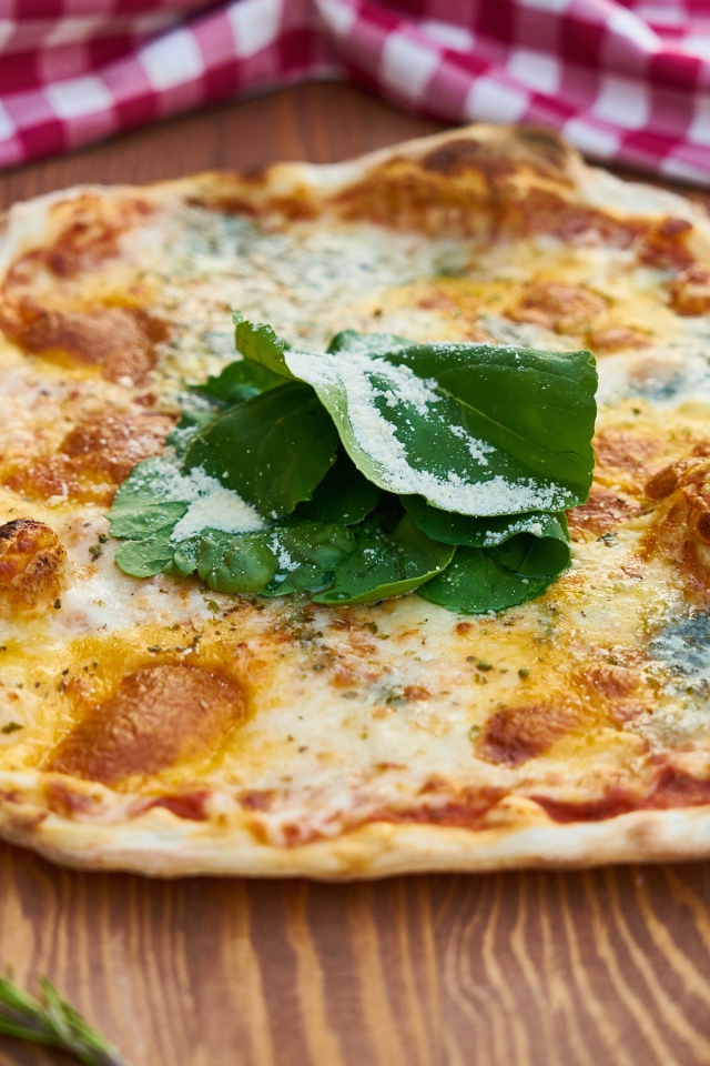 Румяная пицца на столе с овощами