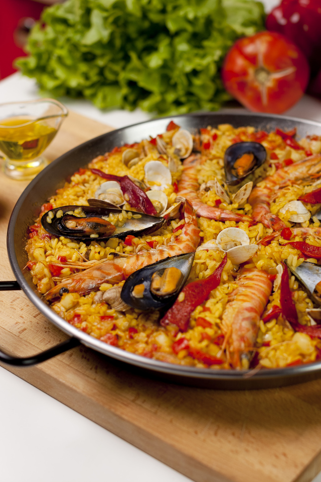 Плов с морепродуктами на столе с овощами