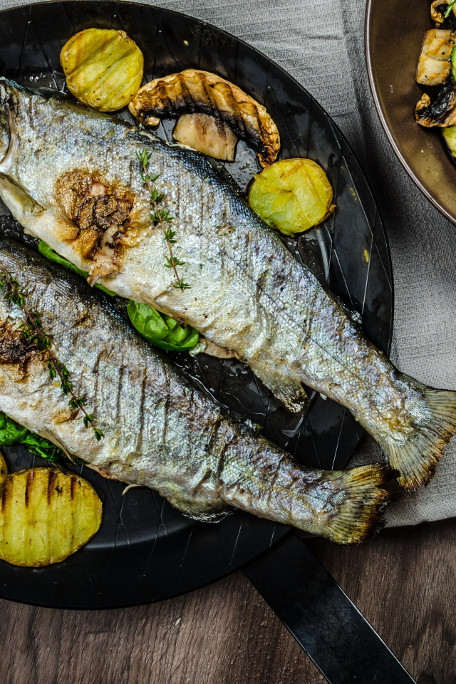 Две рыбины на сковороде с овощами