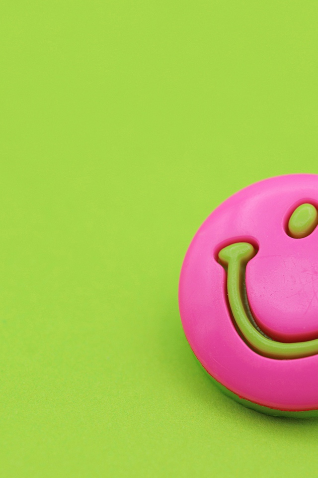 Розовый смайл на зеленом фоне