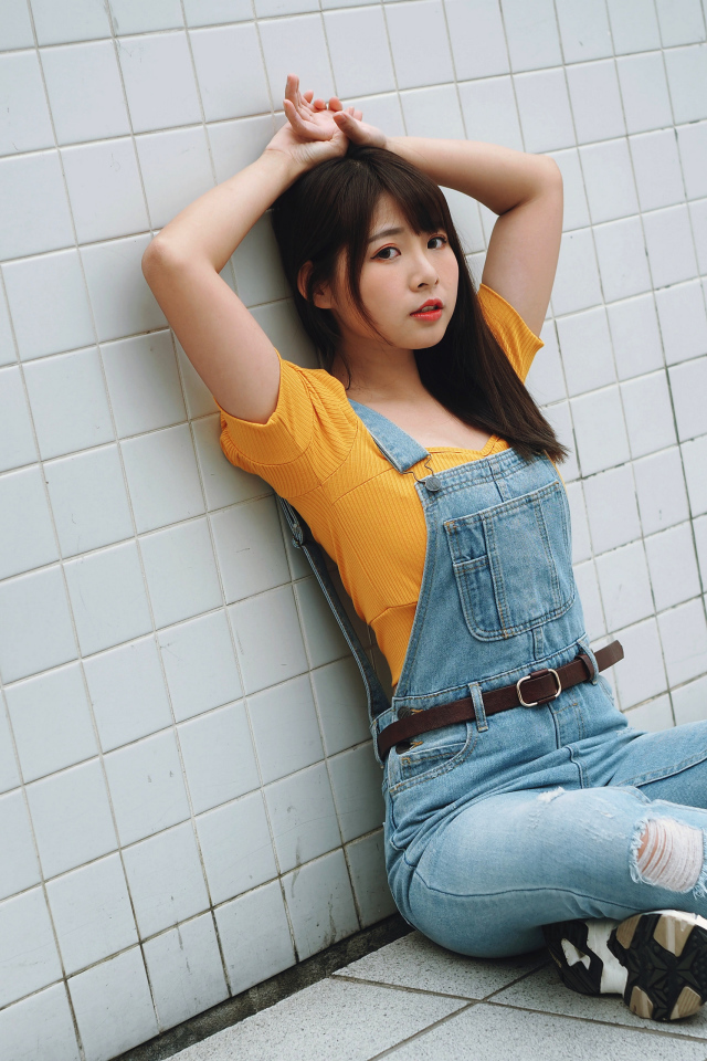 Девушка азиатка в джинсовом комбинезоне 