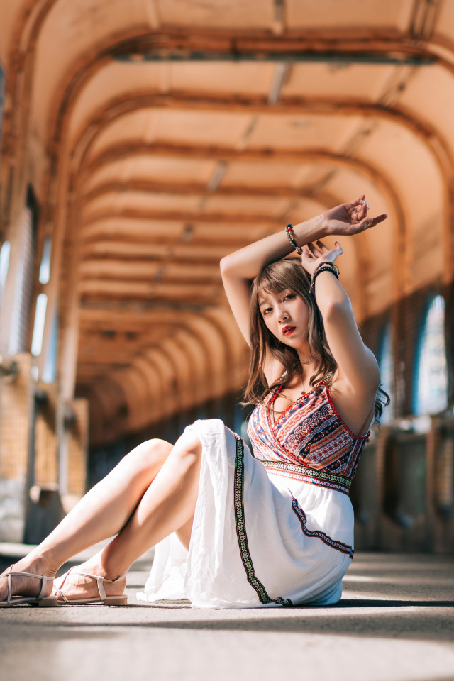 Девушка азиатка сидит в переходе 