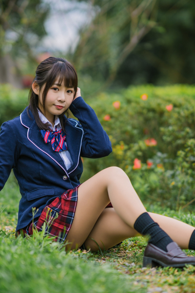 Asian school girl sitting on the grass