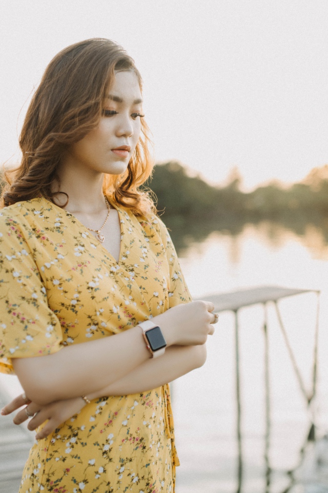 Красивая девушка азиатка стоит у реки 