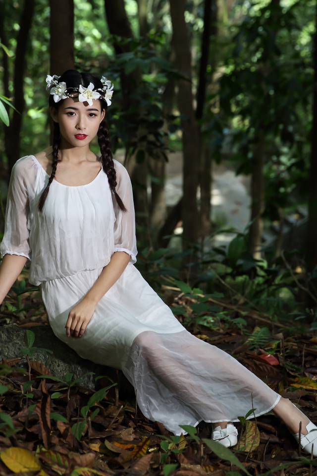Красивая девушка азиатка в белом платье  в лесу