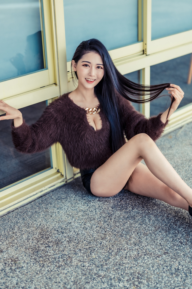 Красивая девушка азиатка в черных туфлях на земле 