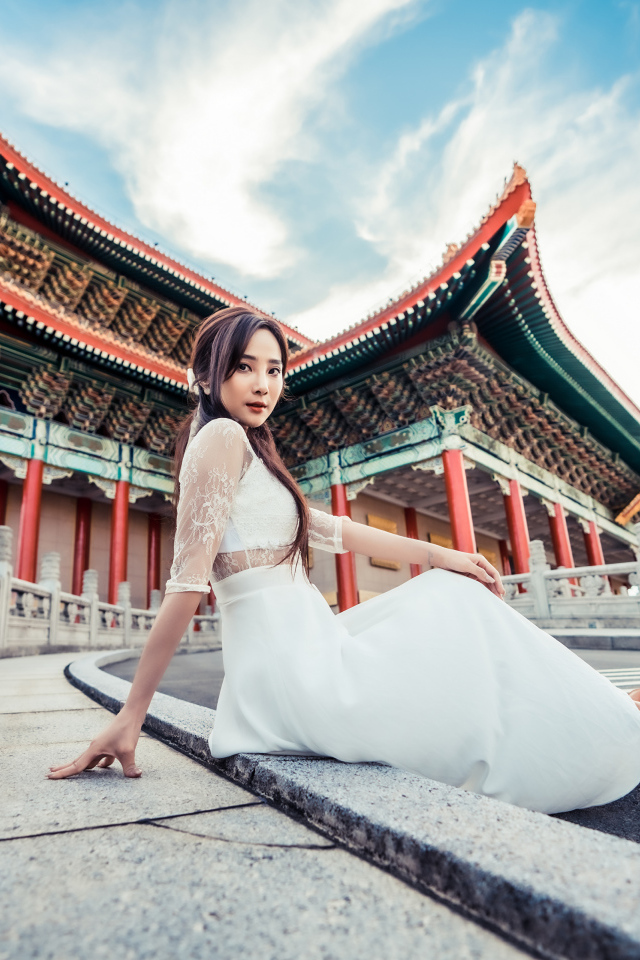 Красивая азиатка в белом платье на фоне храма
