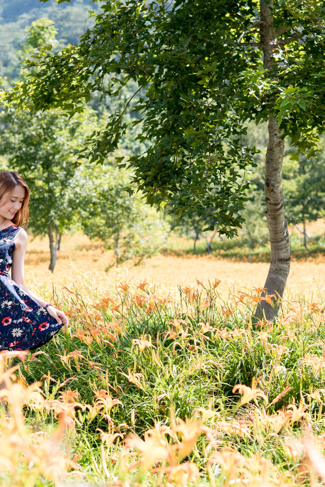 Красивая азиатка гуляет по высокой траве