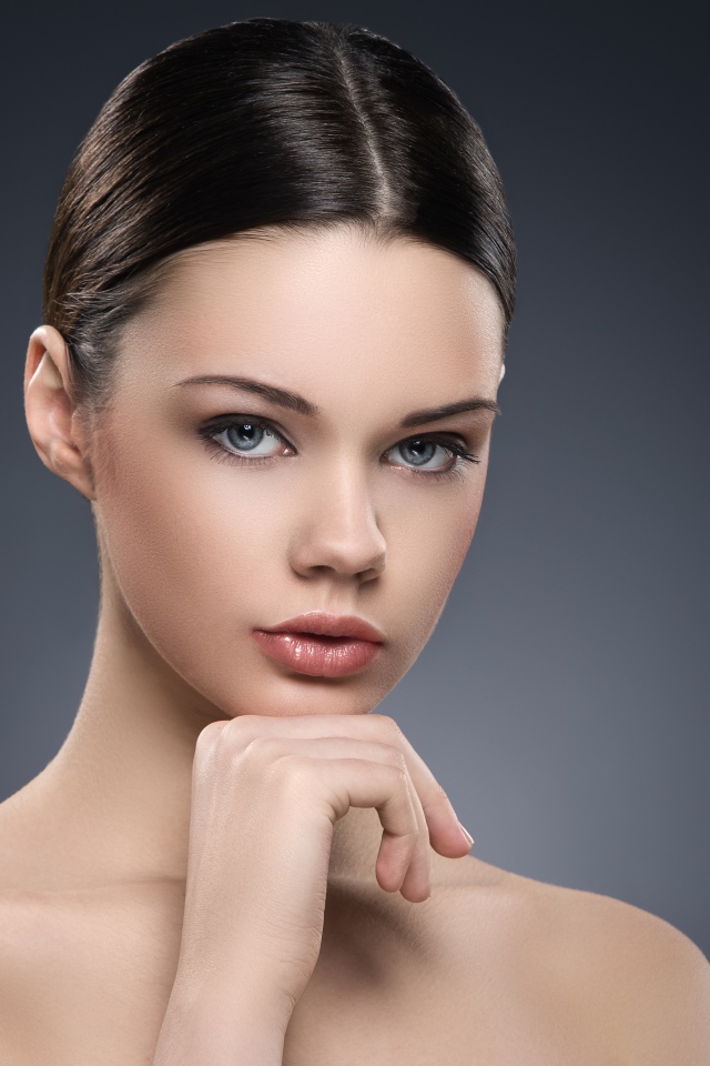 Красивая голубоглазая девушка на сером фоне 