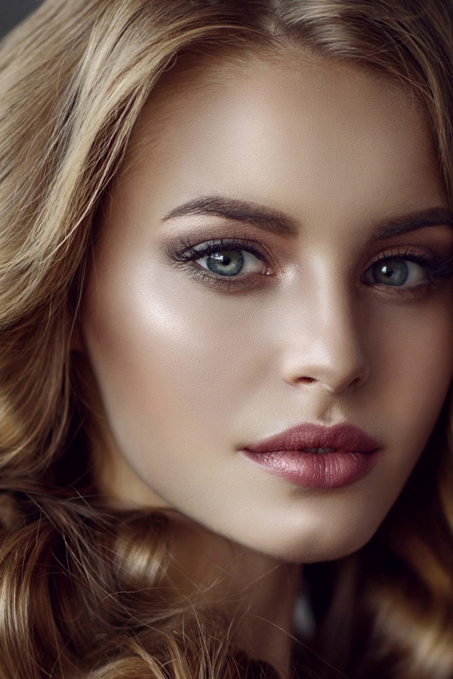 Красивые голубые глаза молодой длинноволосой  девушки