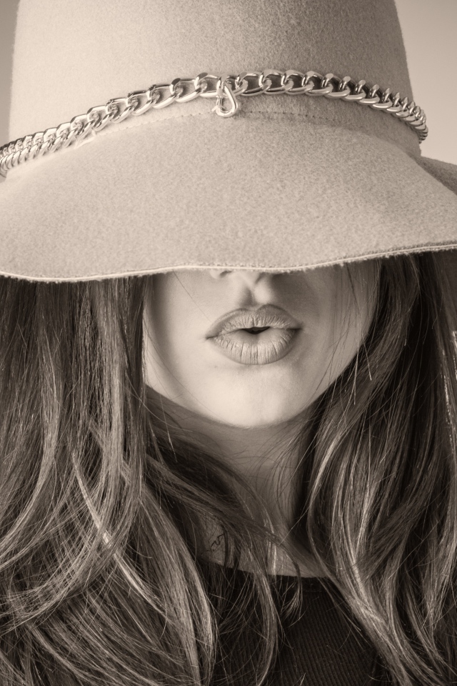 Красивая девушка закрыла лицо шляпой 