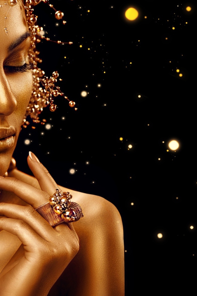 Красивая девушка в золотой краске на черном фоне