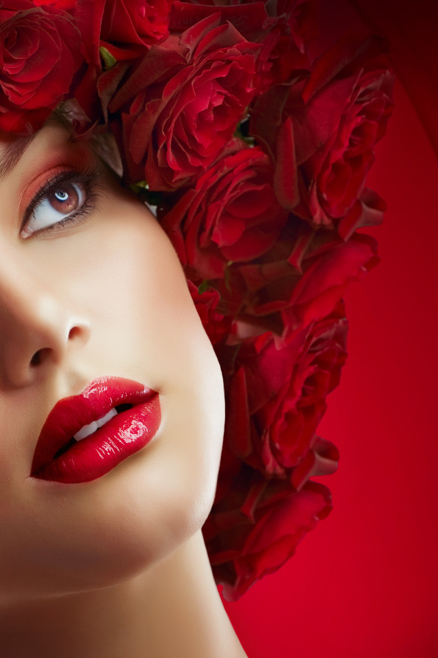 Красивая девушка с венком из роз на голове на красном фоне