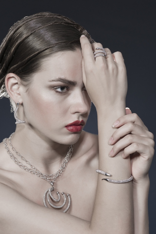 Красивая девушка с украшениями на теле на сером фоне