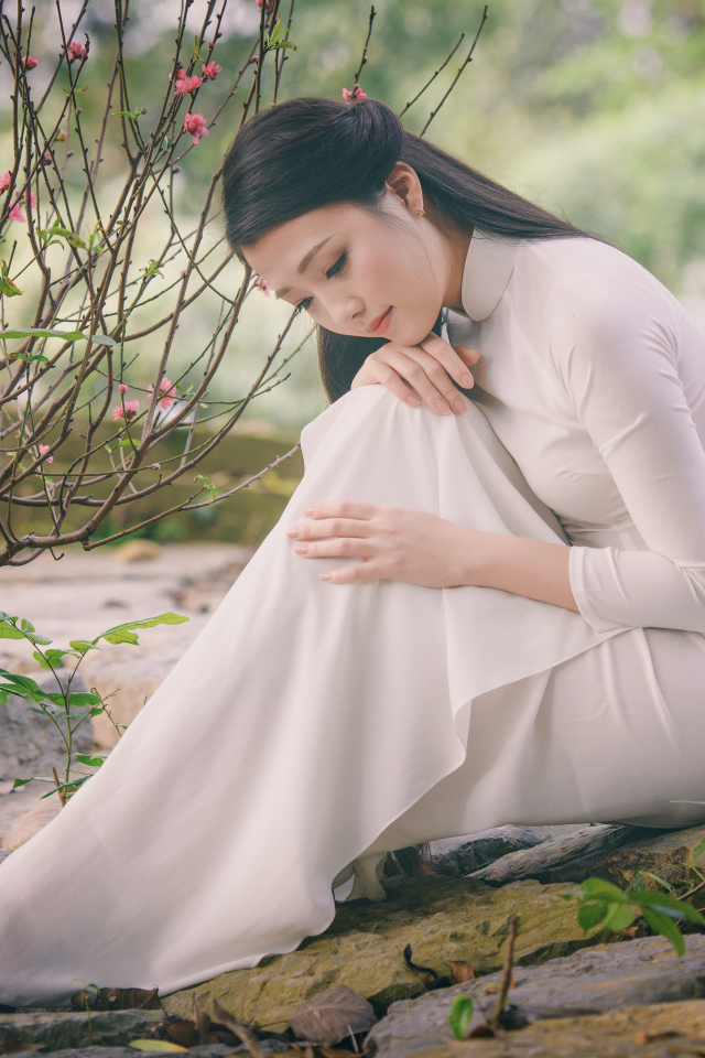 Красивая грустная девушка азиатка в белом платье 