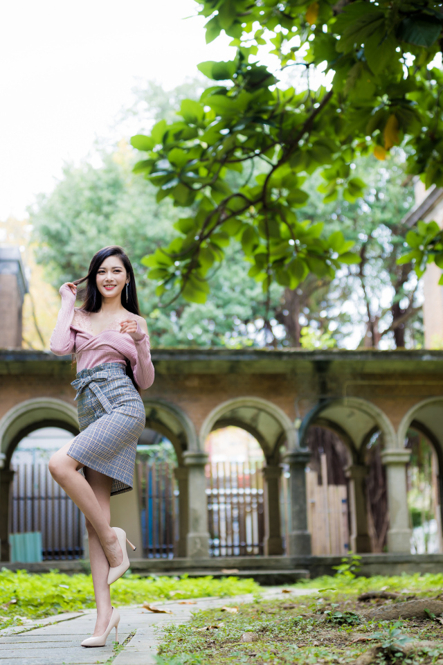 Красивая стройная азиатка на фоне здания