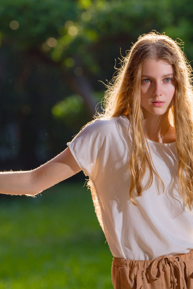 Красивая нежная девушка стоит у стены 