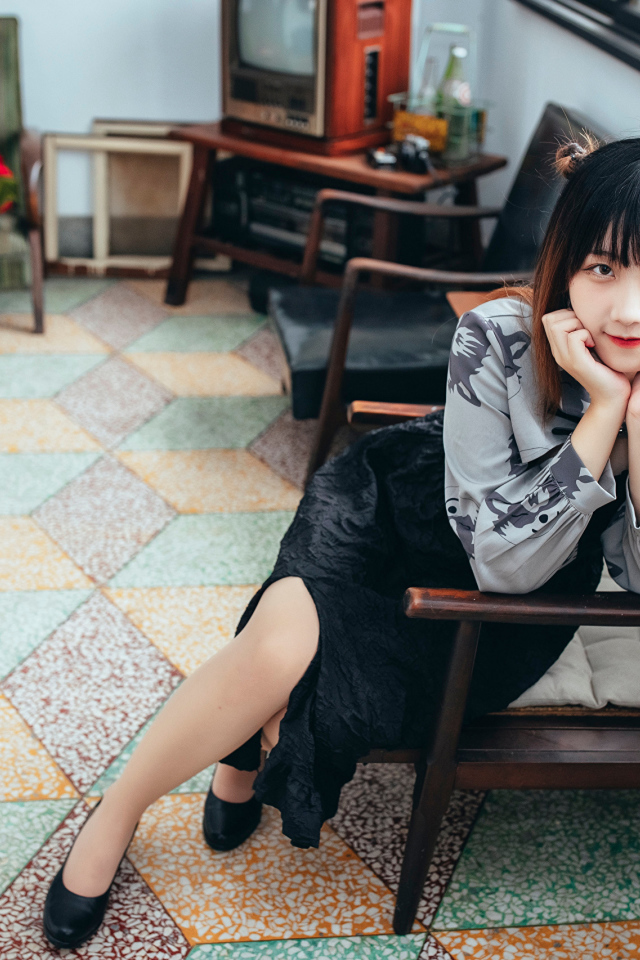 Красивая молодая азиатка сидит в кресле