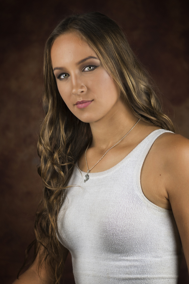 Красивая молодая девушка с длинными волосами в белой майке 