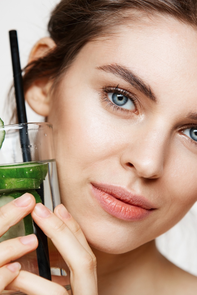 Голубоглазая девушка с огуречным напитком в руке 