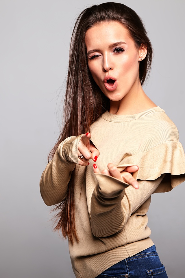 Яркая длинноволосая девушка на сером фоне 