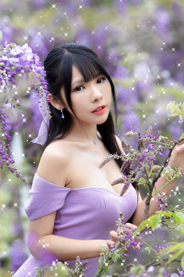 Кареглазая азиатка у куста с цветами глицинии