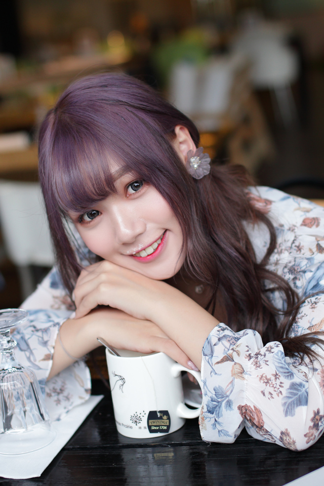 Милая девушка азиатка сидит за столиком