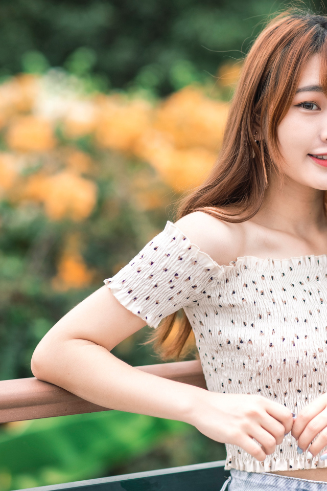 Милая девушка азиатка стоит у перил