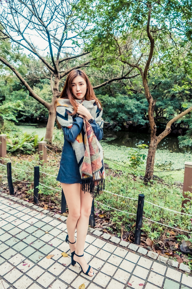 Милая девушка азиатка стоит в осеннем парке 